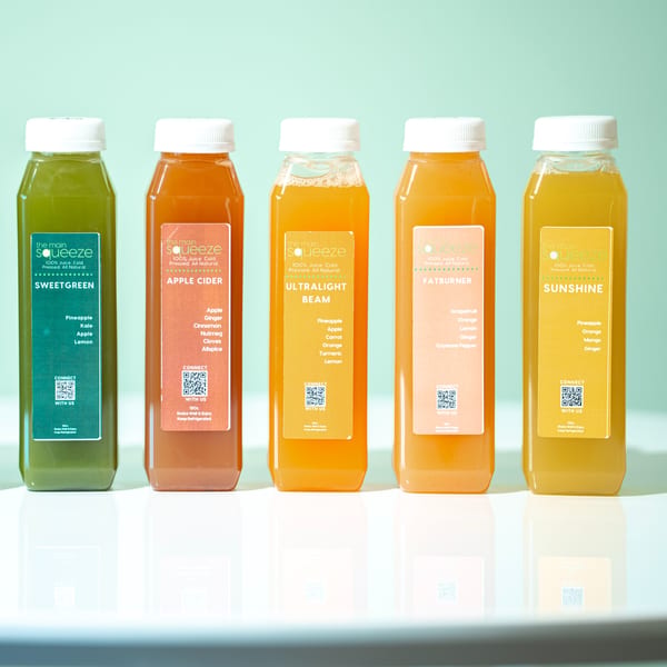 Five bottles of The Main Squeeze cold-pressed juices in various colors and flavors.